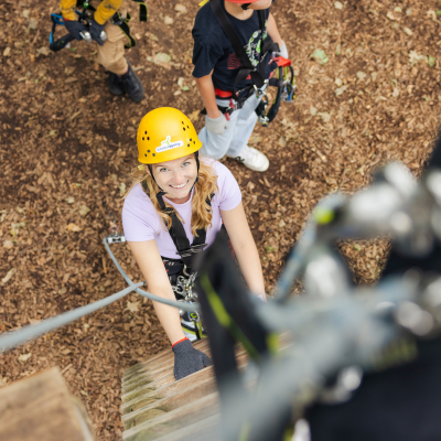 Junge Frau Arm in Arm mit zwei Kindern in Kletterausr�stung lachen in die Kamera