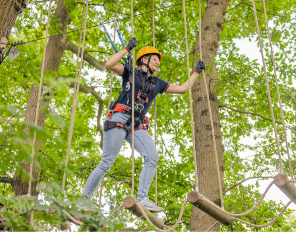 Eine Gruppe Jugendlicher klettert von Element zu Element